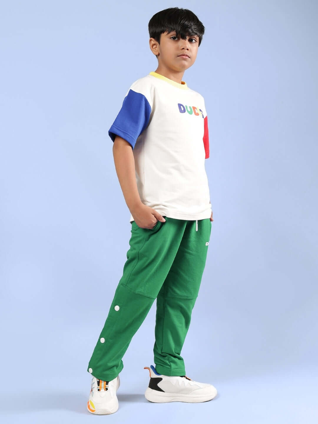 Alt Tag: Boy wearing ADONIS co-ord set in off white and green, featuring a color-blocked shirt and green pants, by DUDS.