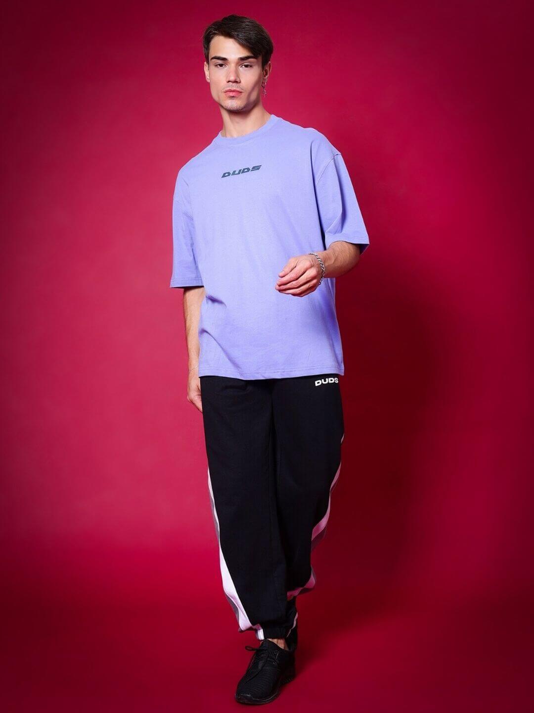 Model wearing BREATHE OVER-SIZED T-SHIRT PERIWINKLE against red background