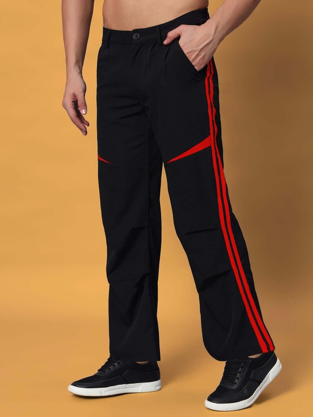 Man wearing DROVE Relaxed Fit Cargo Pants in black with red accents, showcasing stylish design for a casual look.