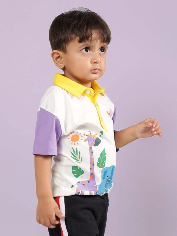 Young child wearing a colorful animal-themed polo shirt with yellow collar, standing against a purple background.