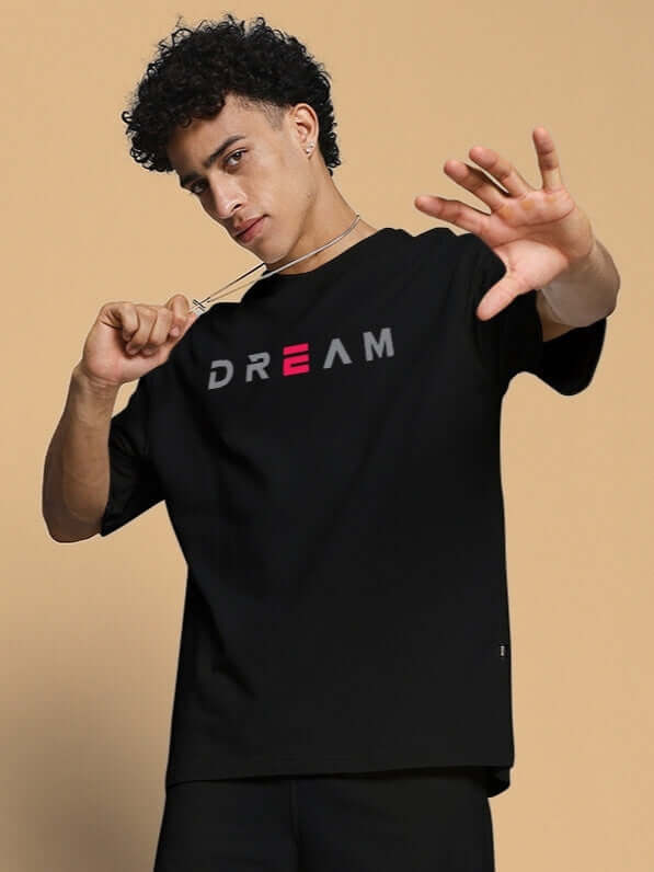 Model wearing black 'FANCY DREAM' oversized t-shirt made of premium cotton French terry, perfect casual wear manufactured in India.