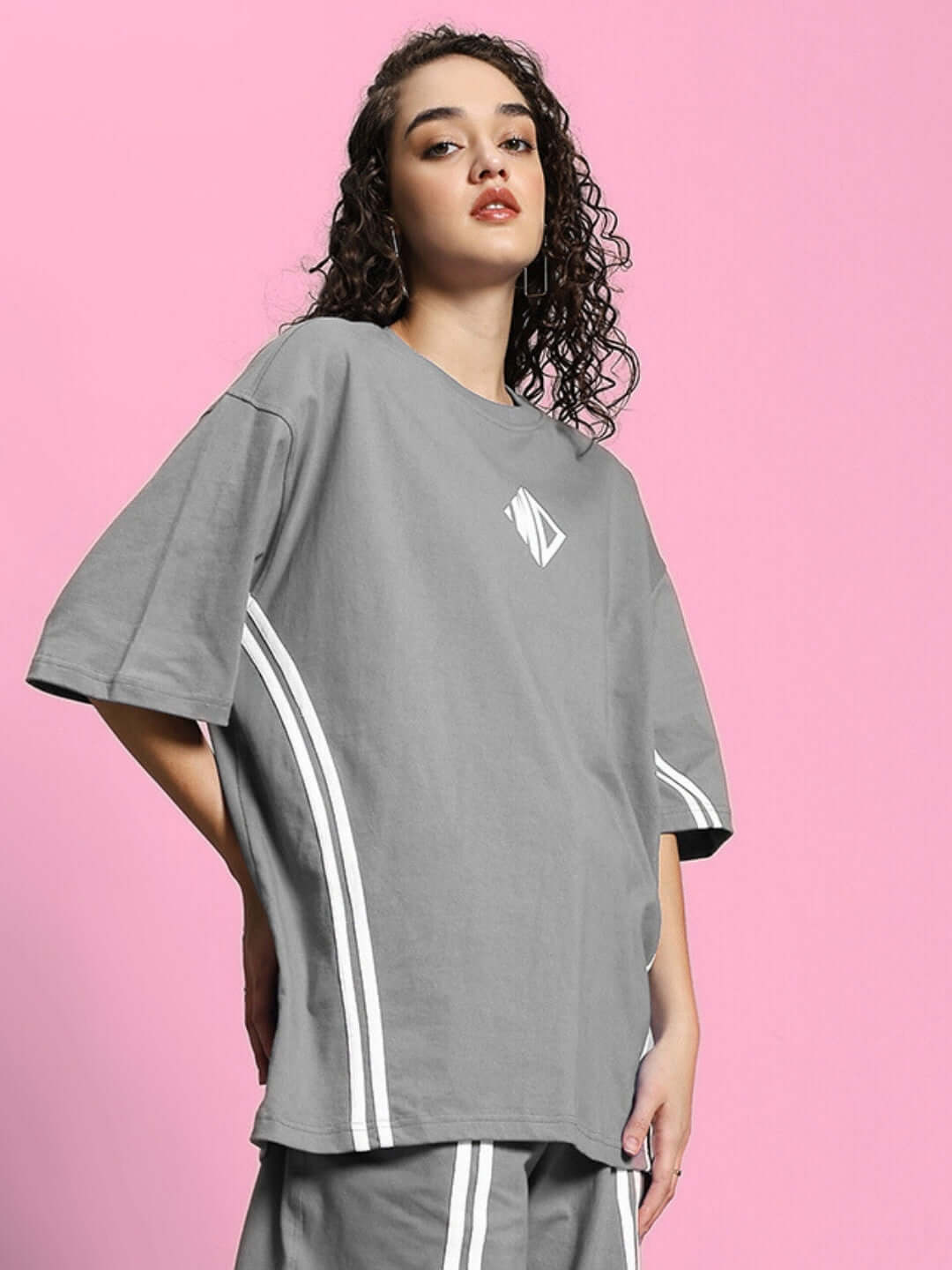 Model wearing women's grey oversized t-shirt made of premium cotton French terry and elastane, showcasing comfort and style.