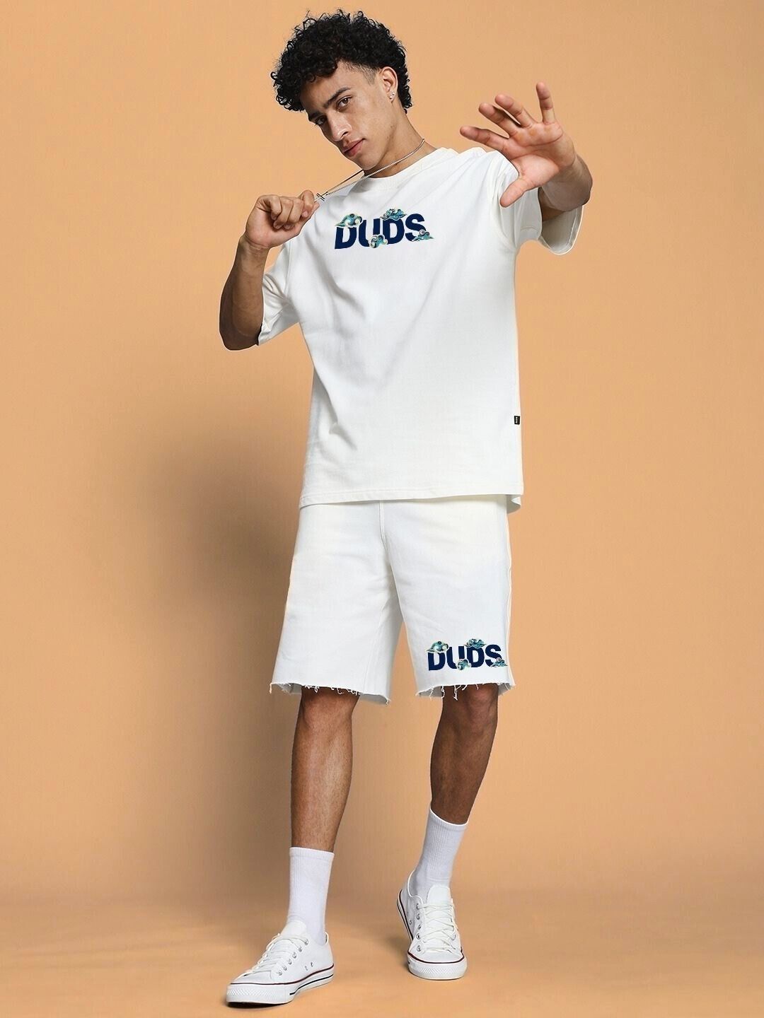 Man wearing stylish off-white co-ord set with cloud prints and text design, showcasing casual chic fashion.