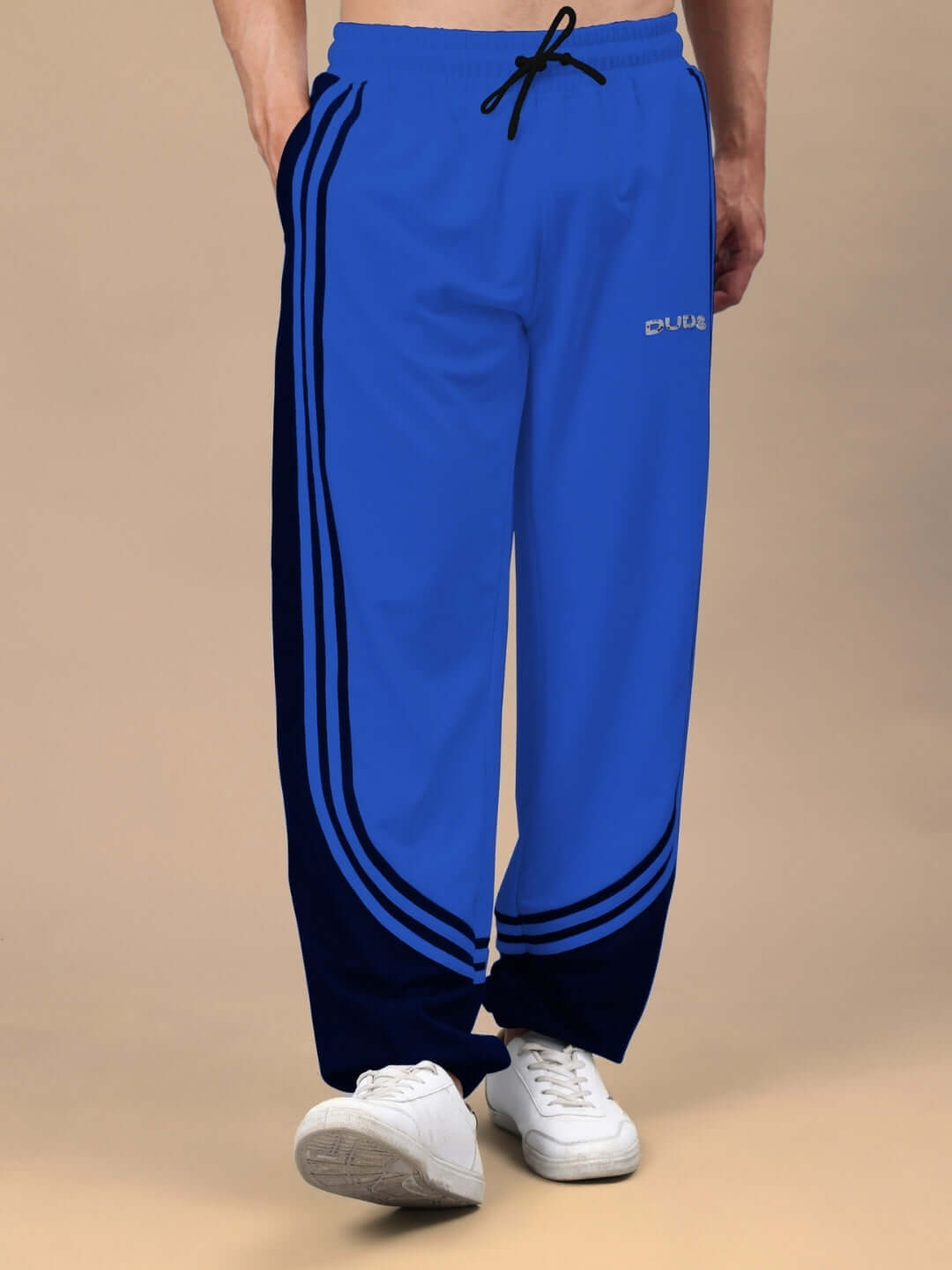 Model wearing Frenzy Curve Contrast Joggers in blue and black, showcasing the stylish design by DUDS. Perfect for a custom fit option.