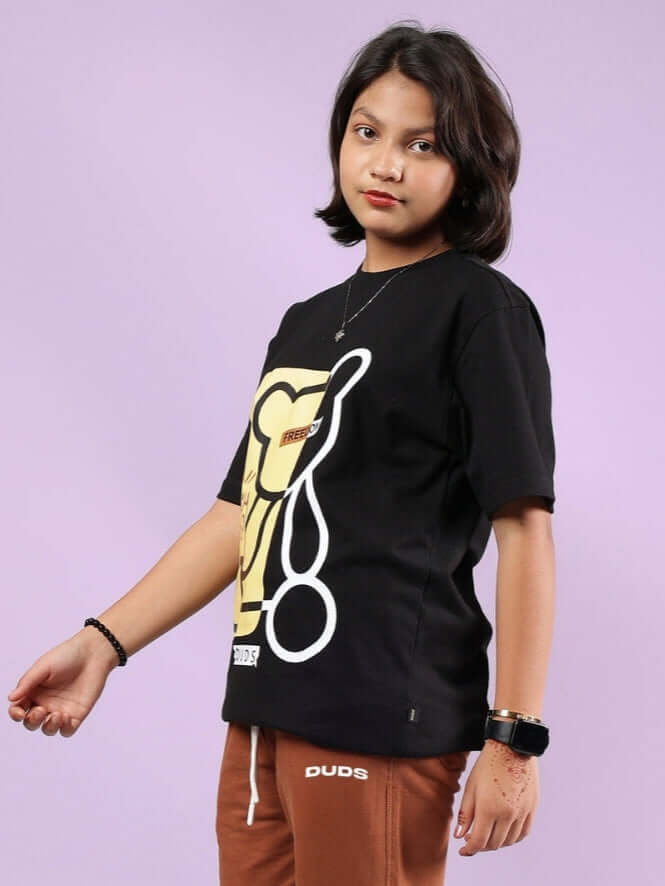 Young person wearing a black Honey-Bunny T-shirt by DUDS, with a playful design, suitable for both boys and girls.