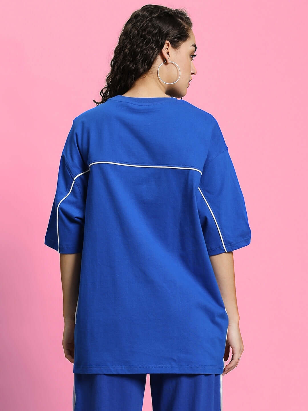 Back view of woman's oversized classic blue T-shirt, highlighting premium cotton fabric with white piping detail. Designed by Color By Colours.