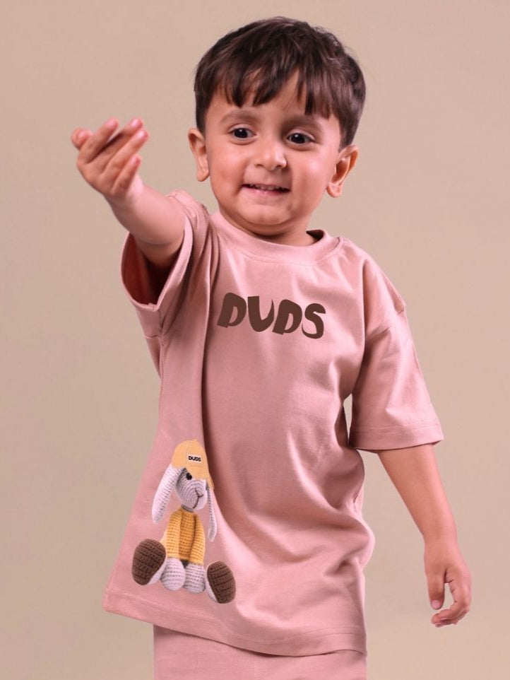 Child wearing a beige Flint Bunny T-shirt with bunny graphic, unisex design for boys and girls.