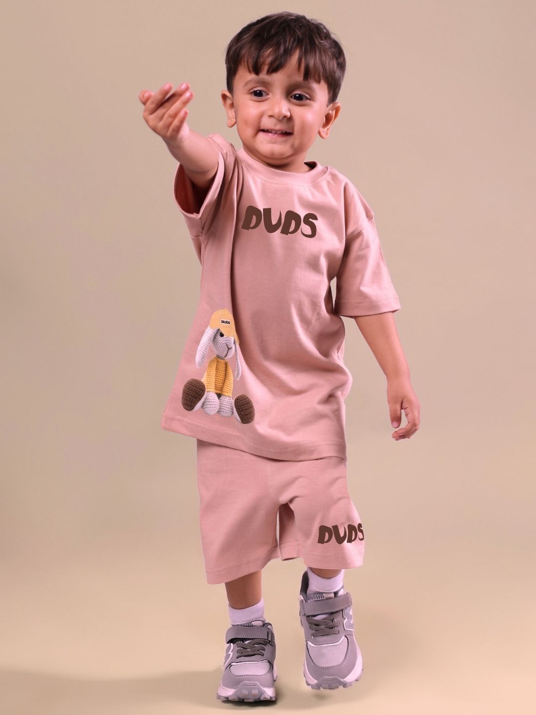 Child wearing unisex beige Flint Bunny co-ord set with bunny design, suitable for boys and girls, featuring matching shorts and shirt.