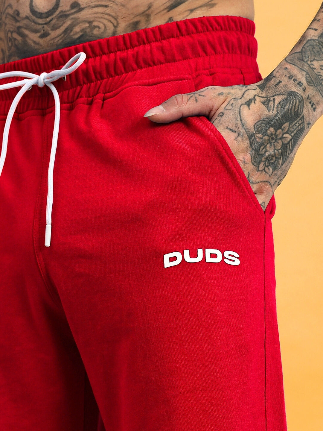 Red HERSHEY Side Slit Joggers by DUDS, featuring adjustable drawstring and side pocket, highlighting craftsmanship.