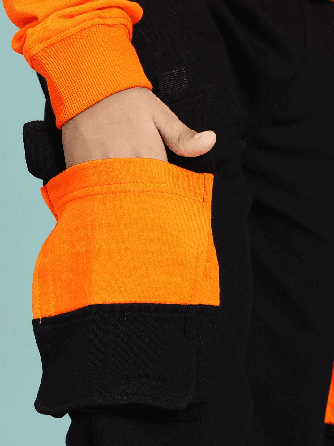 Close-up of TIGON KIDS CO-ORD SET FOR BOYS AND GIRLS ORANGE BLACK showcasing orange pocket detail.