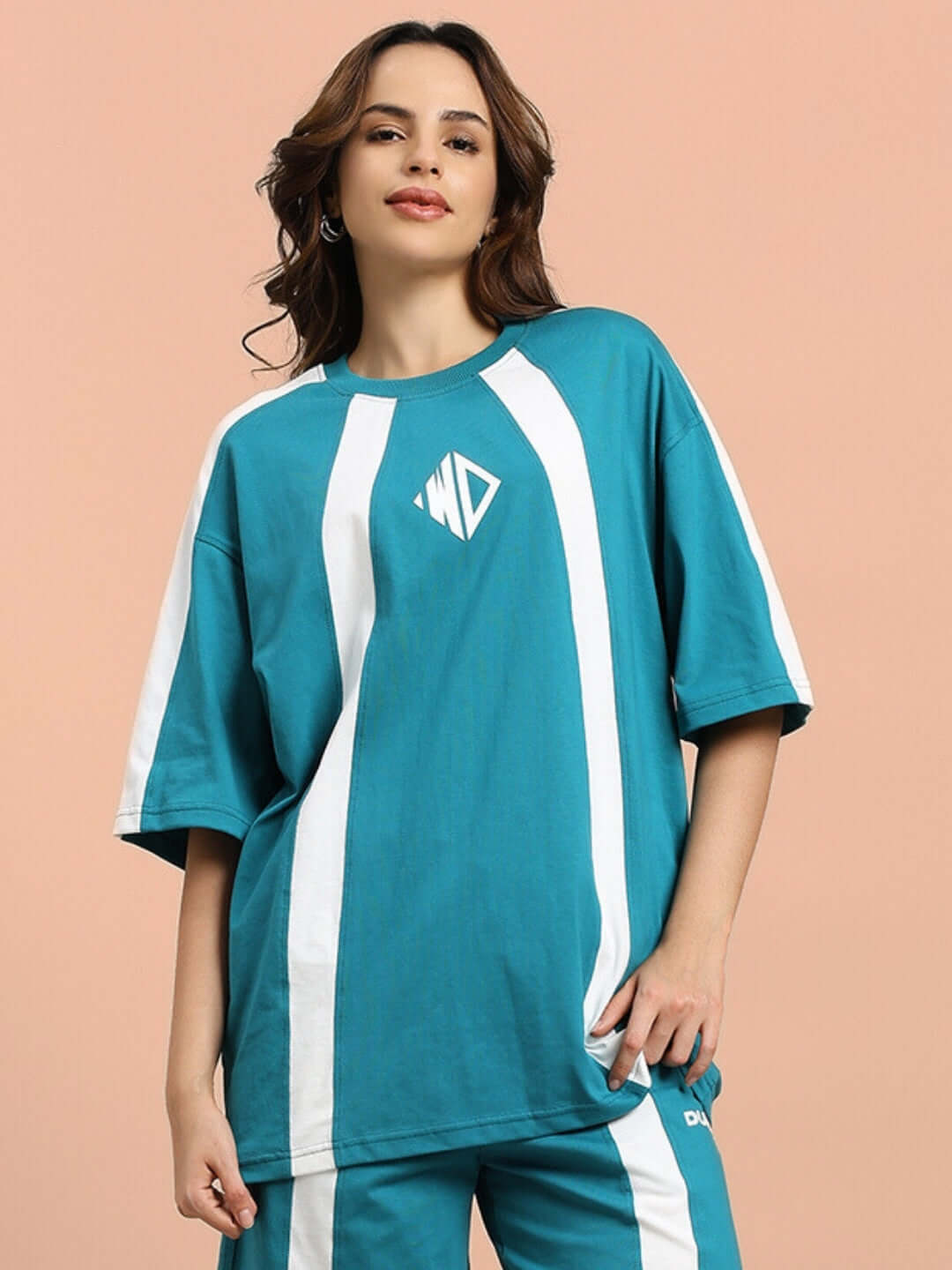Model wearing women's wideline oversized teal t-shirt made from premium cotton French terry, designed with white stripes.