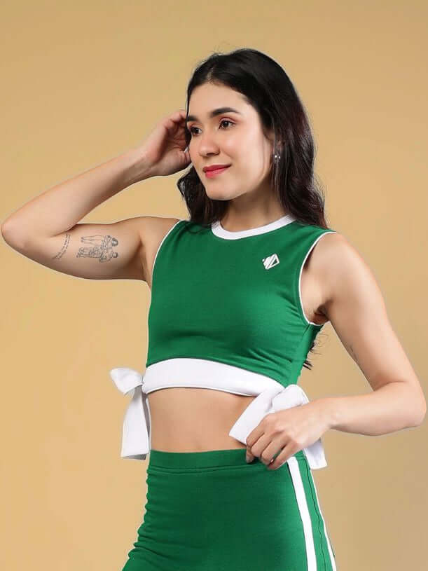 WOMENS FITTONIA COOL CROP TOP GREEN worn by a woman, showcasing modern style and comfort in a vibrant green color.