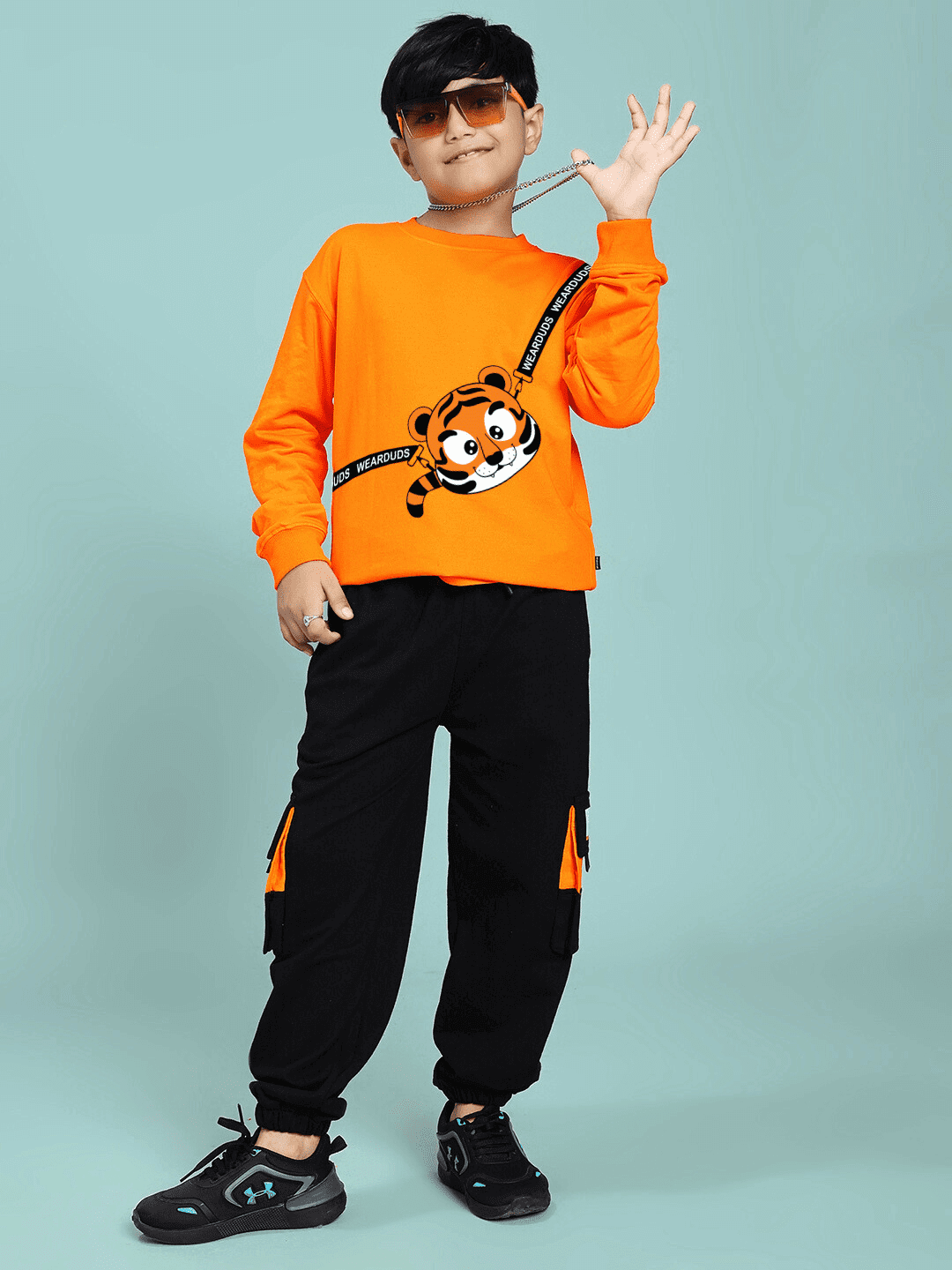 Boy wearing TIGON KIDS CO-ORD SET FOR BOYS AND GIRLS ORANGE BLACK showing stylish and sporty outfit.