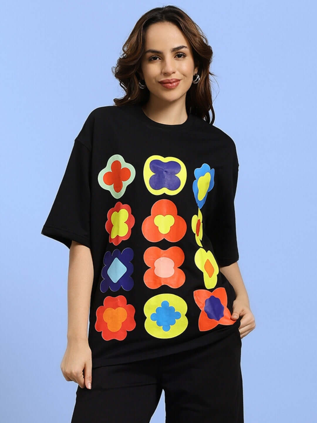 Woman wearing a black Hollister oversized T-shirt with colorful geometric prints, made from premium cotton French terry, casual fashion.