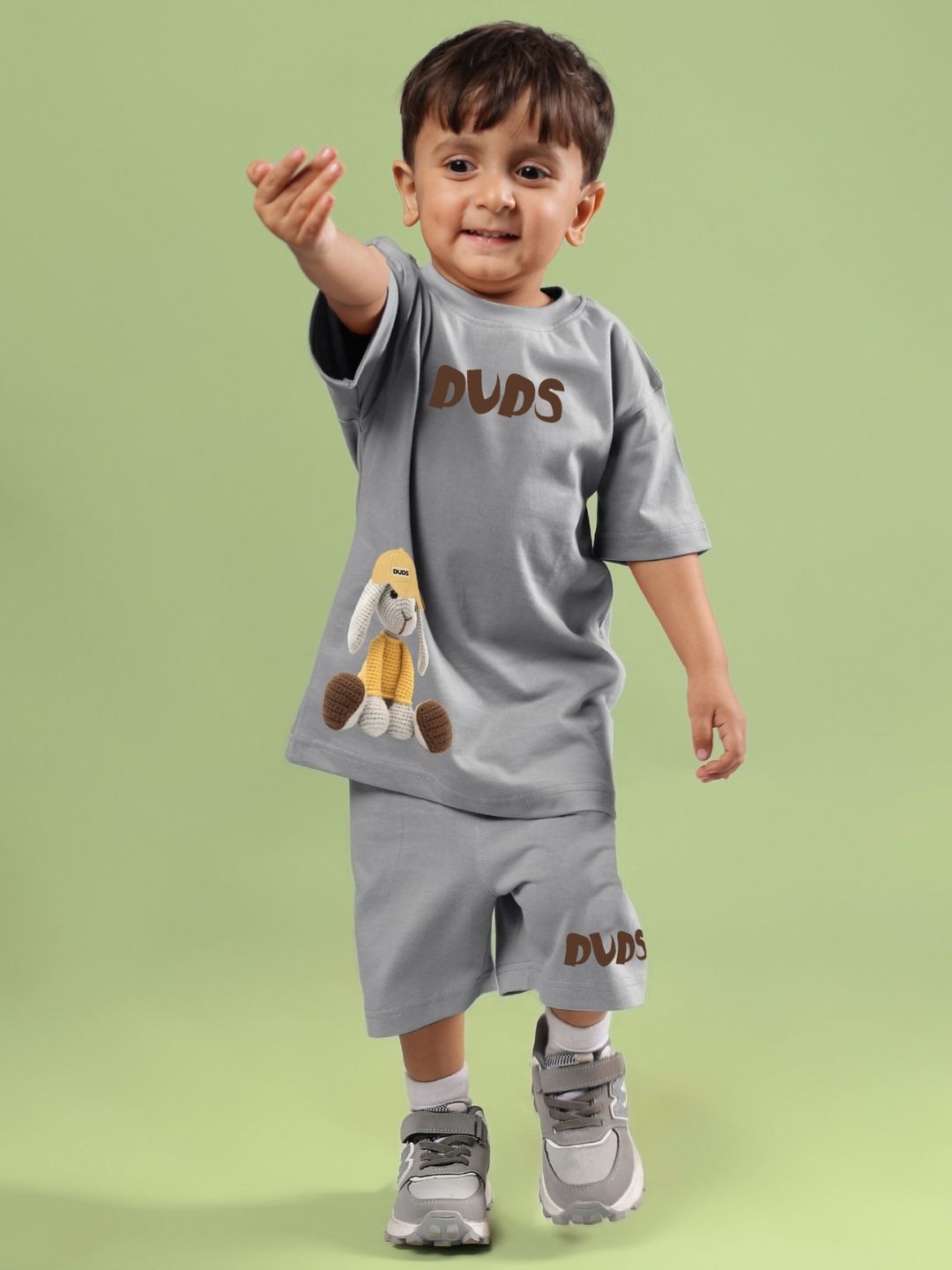 Child wearing Flint Bunny Co-ord set for boys and girls in grey, featuring bunny-themed design, standing on a green background.
