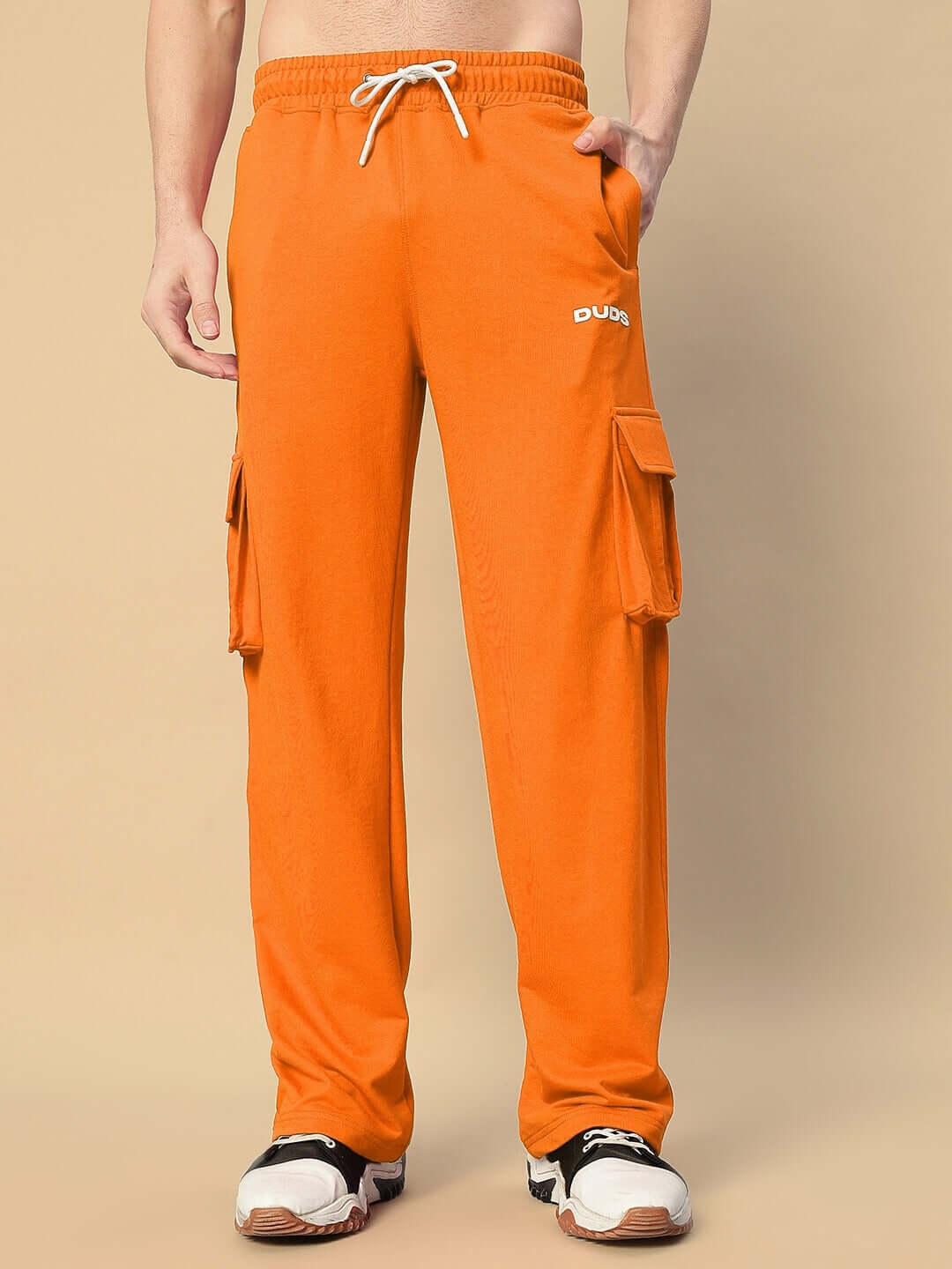 Man wearing orange JESS 5 Pocket Relaxed Fit Joggers by DUDS, featuring cargo pockets and drawstring waist, perfect for casual wear.