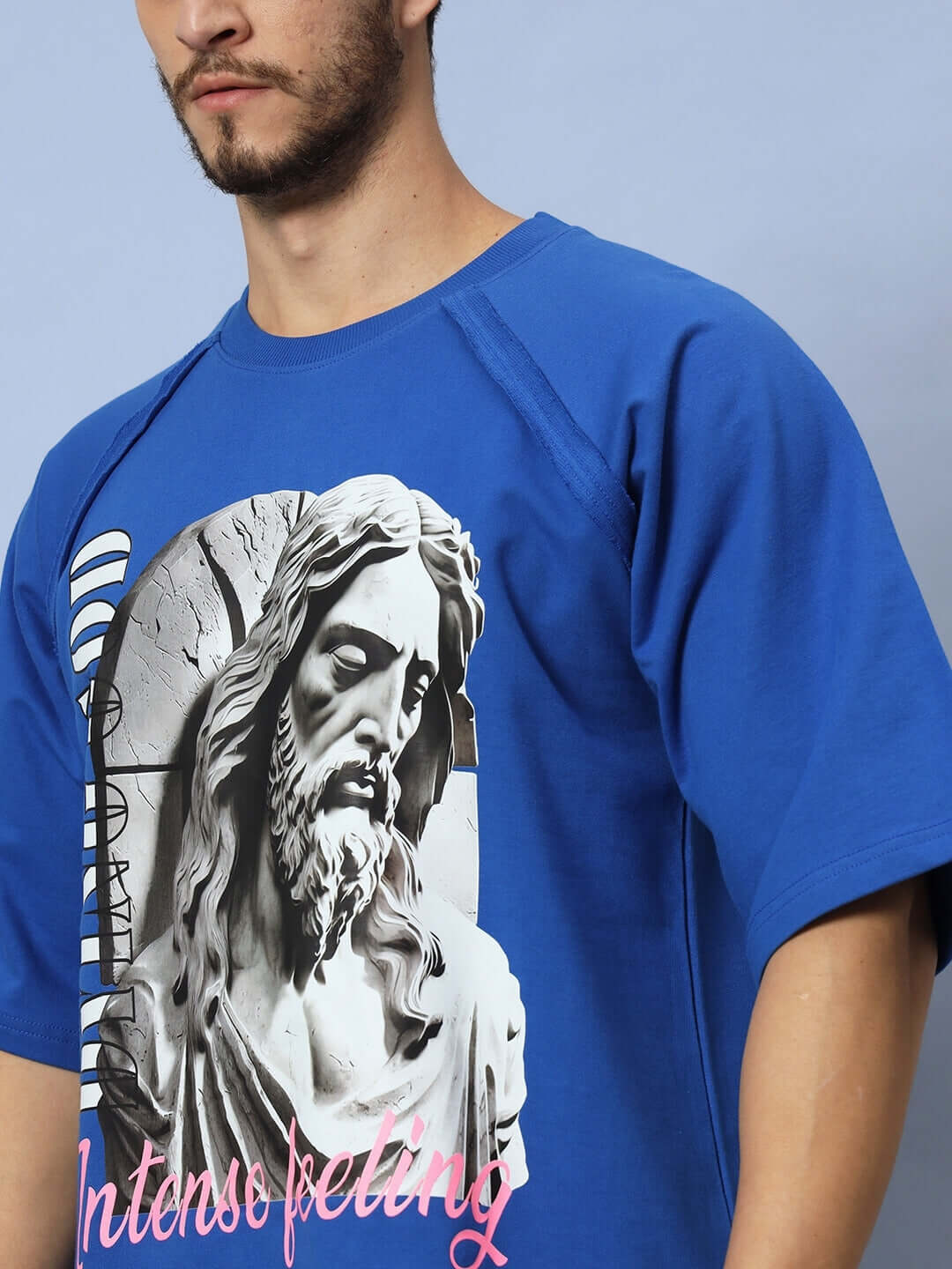 Person wearing REGLAN DYING GOD OVER-SIZED T-SHIRT ROYAL BLUE featuring Intenso feeling print.