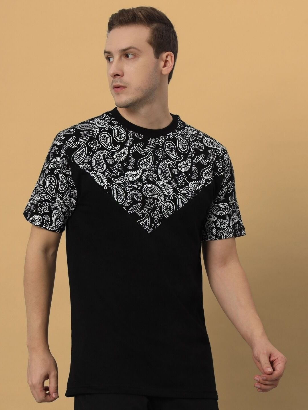 Model wearing BALLADEER over-sized black T-shirt with paisley pattern, made from premium cotton French terry fabric.
