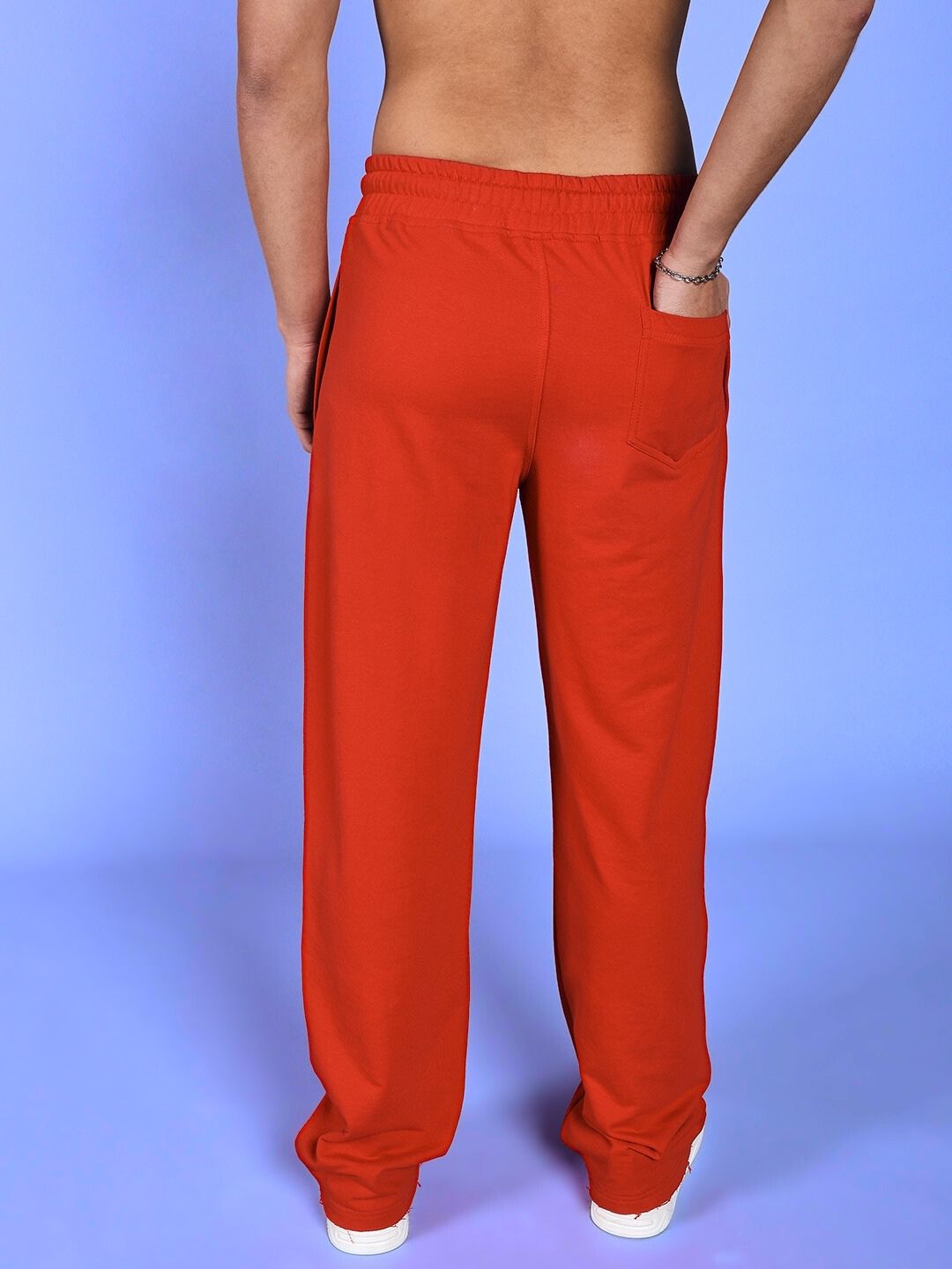 Back view of SKELETONS LOVE RELAXED FIT JOGGER RED showcasing relaxed fit and pocket detail against a blue background.