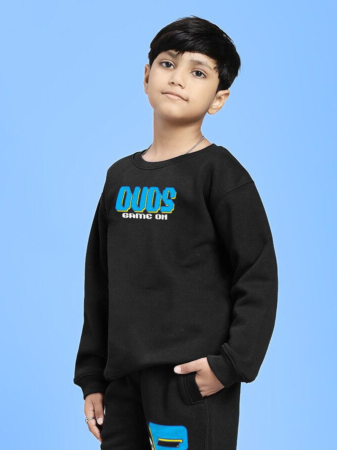 Child wearing GAME ON PRINT FLEECE SWEATSHIRT FOR BOYS GIRLS BLACK, showcasing sporty style with graphic design on blue background.