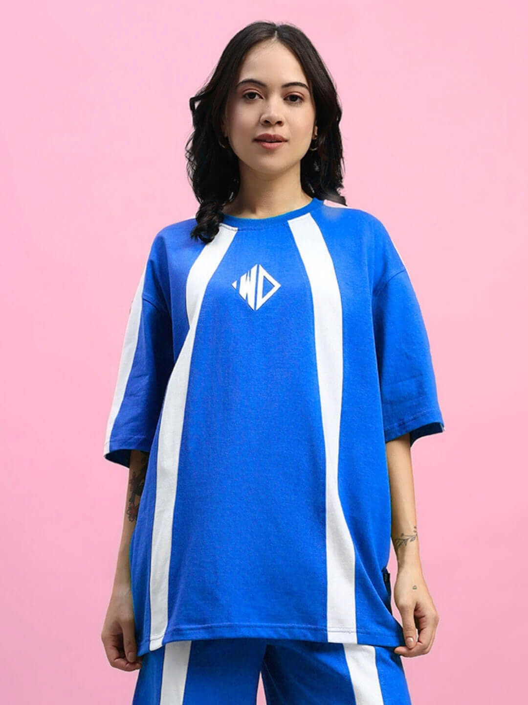 Model wearing women's oversized blue Wideline T-shirt with white stripes, made from premium cotton blend, by Color By Colours.