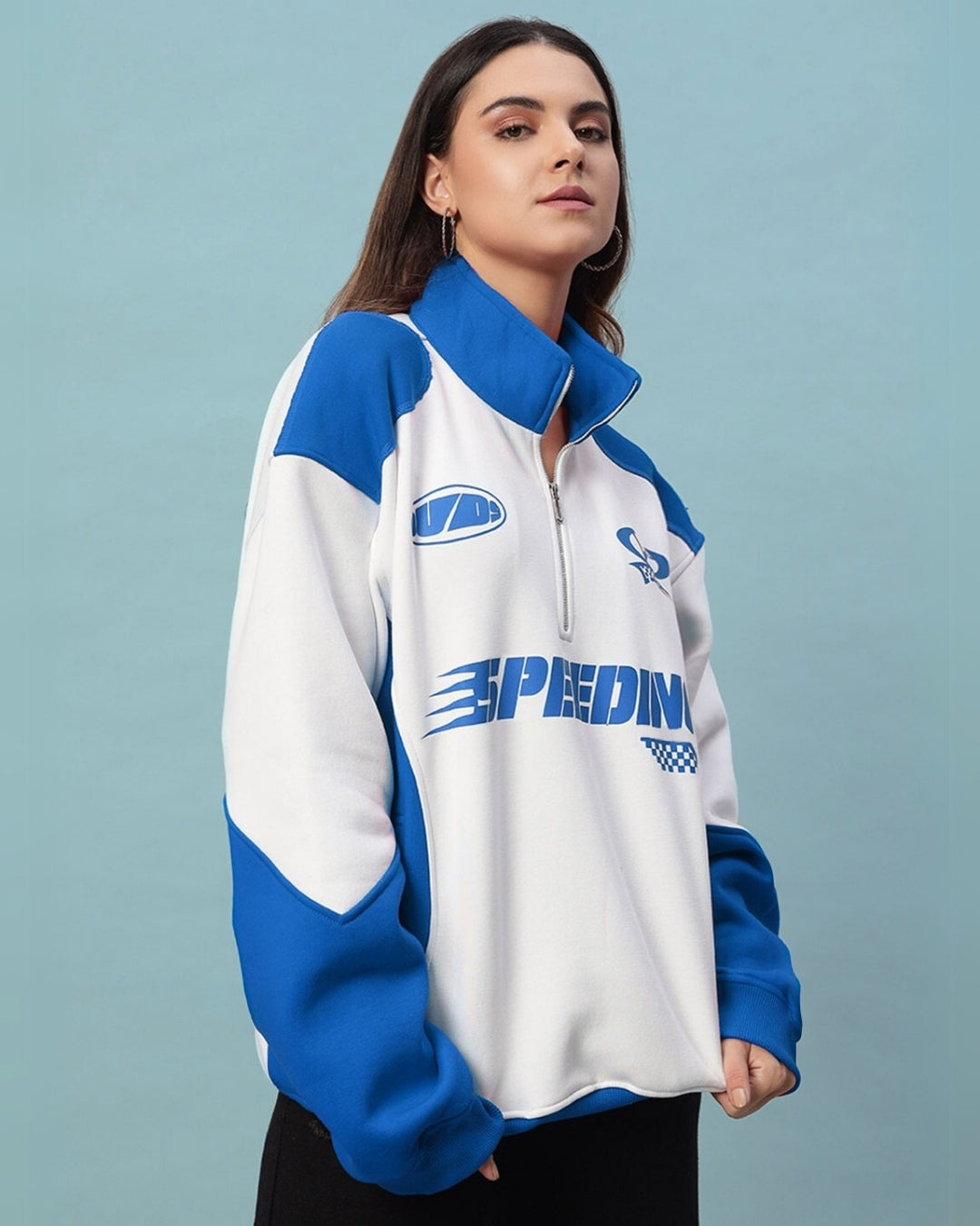 Woman wearing blue and white colorblock jacket with 'Speeding' logo, showcasing sporty style and comfort.