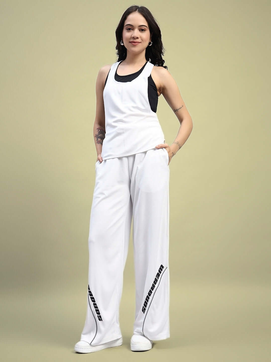 Woman wearing Women's Cubby Co-Ord Set in white, featuring relaxed fit joggers with elastic waistband, made in premium sports polyester.