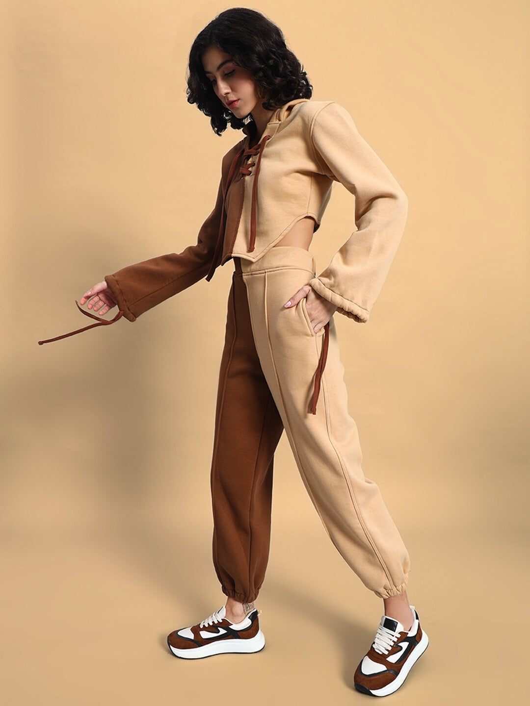 Woman wearing the Women's Sophia Co-Ord Set in beige-brown with neutral tones, showcasing chic style and comfort against a beige background.