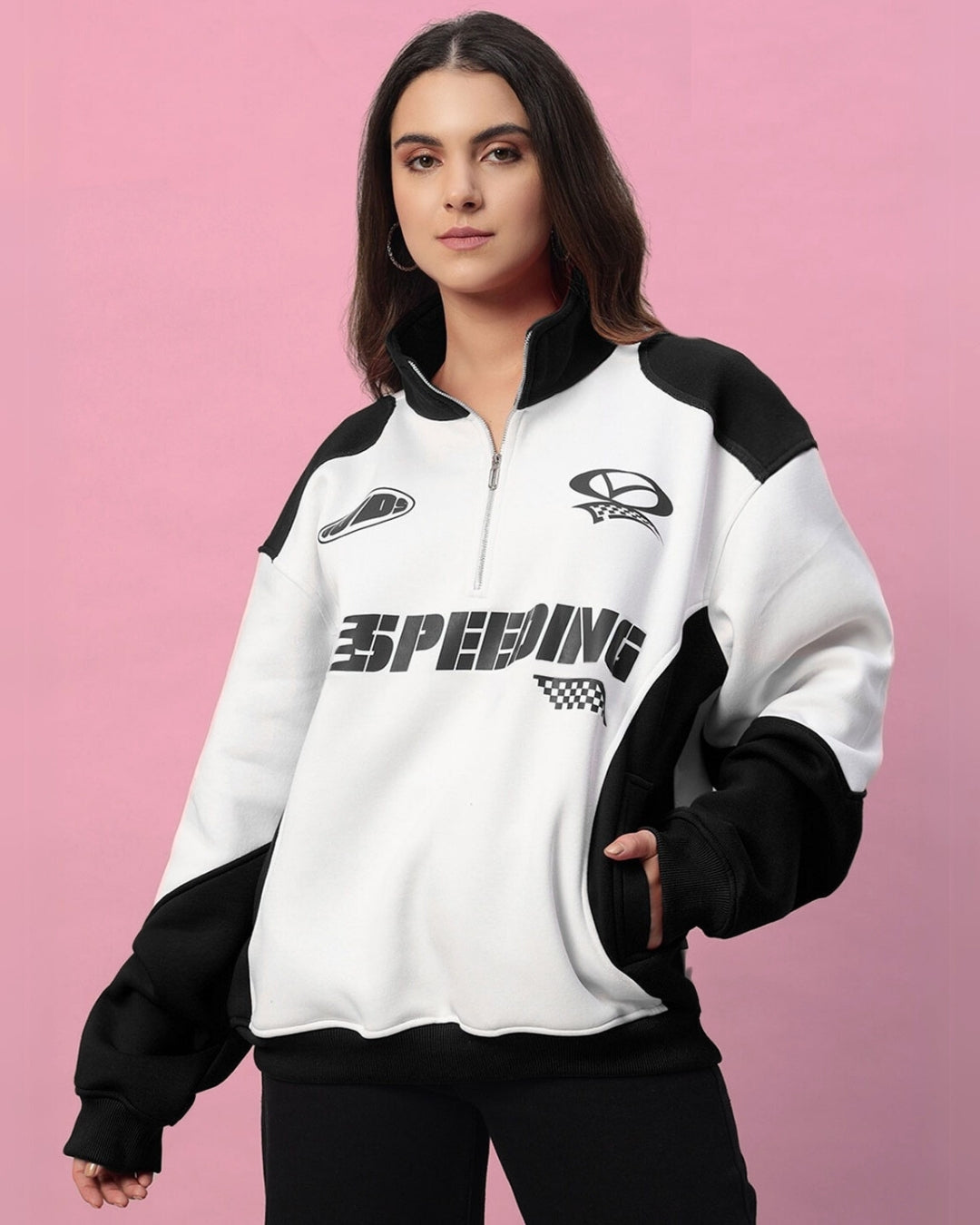 Woman wearing a modern black and white colorblock jacket with bold 'Speeding' text, featuring relaxed fit and premium fleece material.