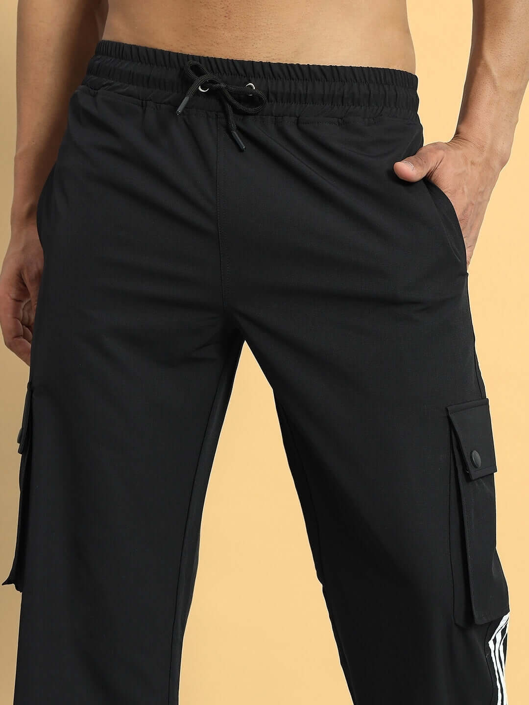 Model wearing NOVA relaxed fit black cargo pants with pockets and drawstring waistband.