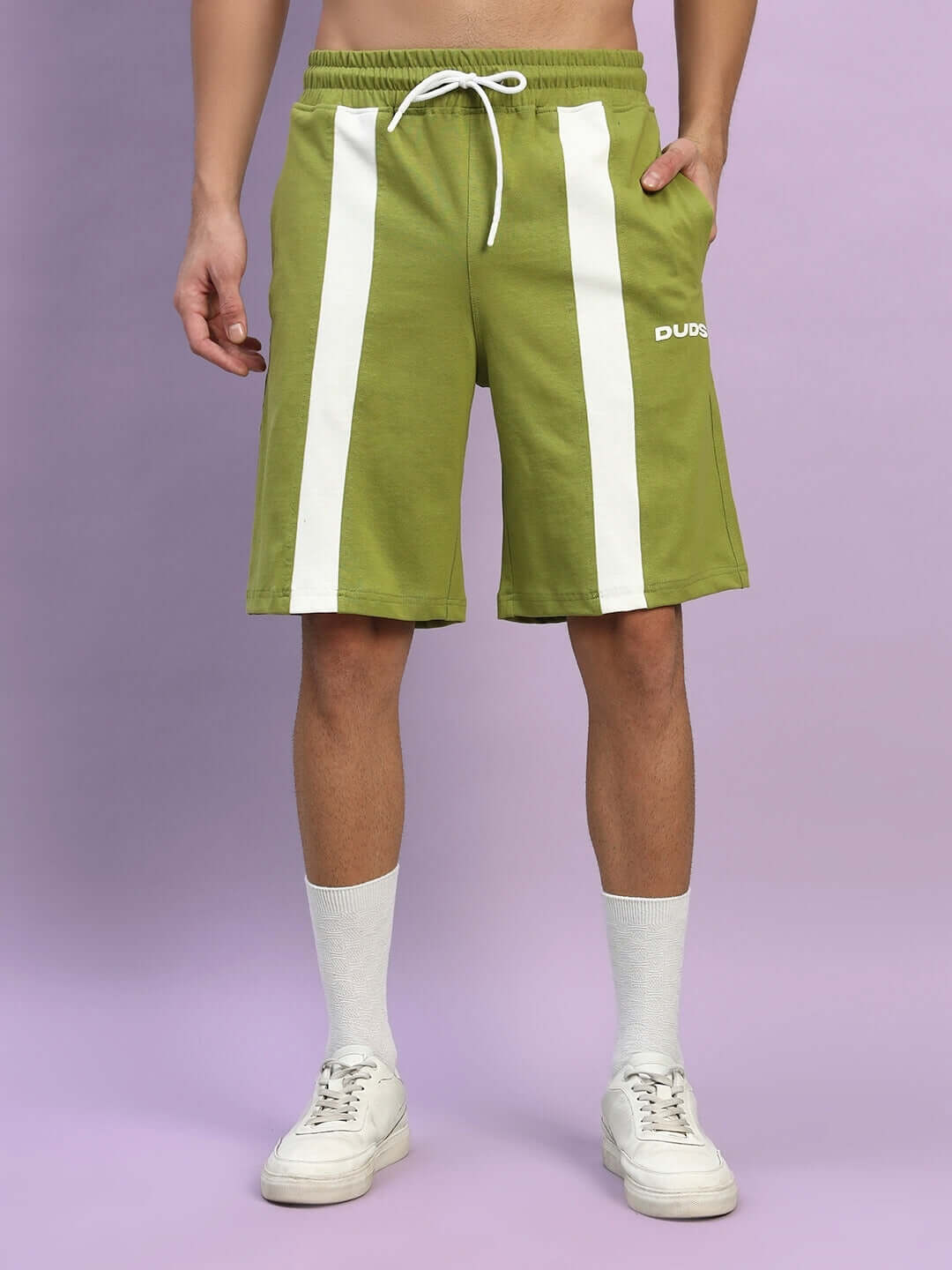 Model wearing olive green Wideline regular fit shorts with white stripes, showcasing drawstring waist and comfortable design.
