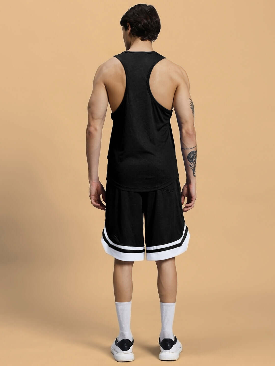 Back view of man wearing black CHANGE YOUR LOOKS gym co-ord set in sports polyester. Perfect for workouts, made in India.