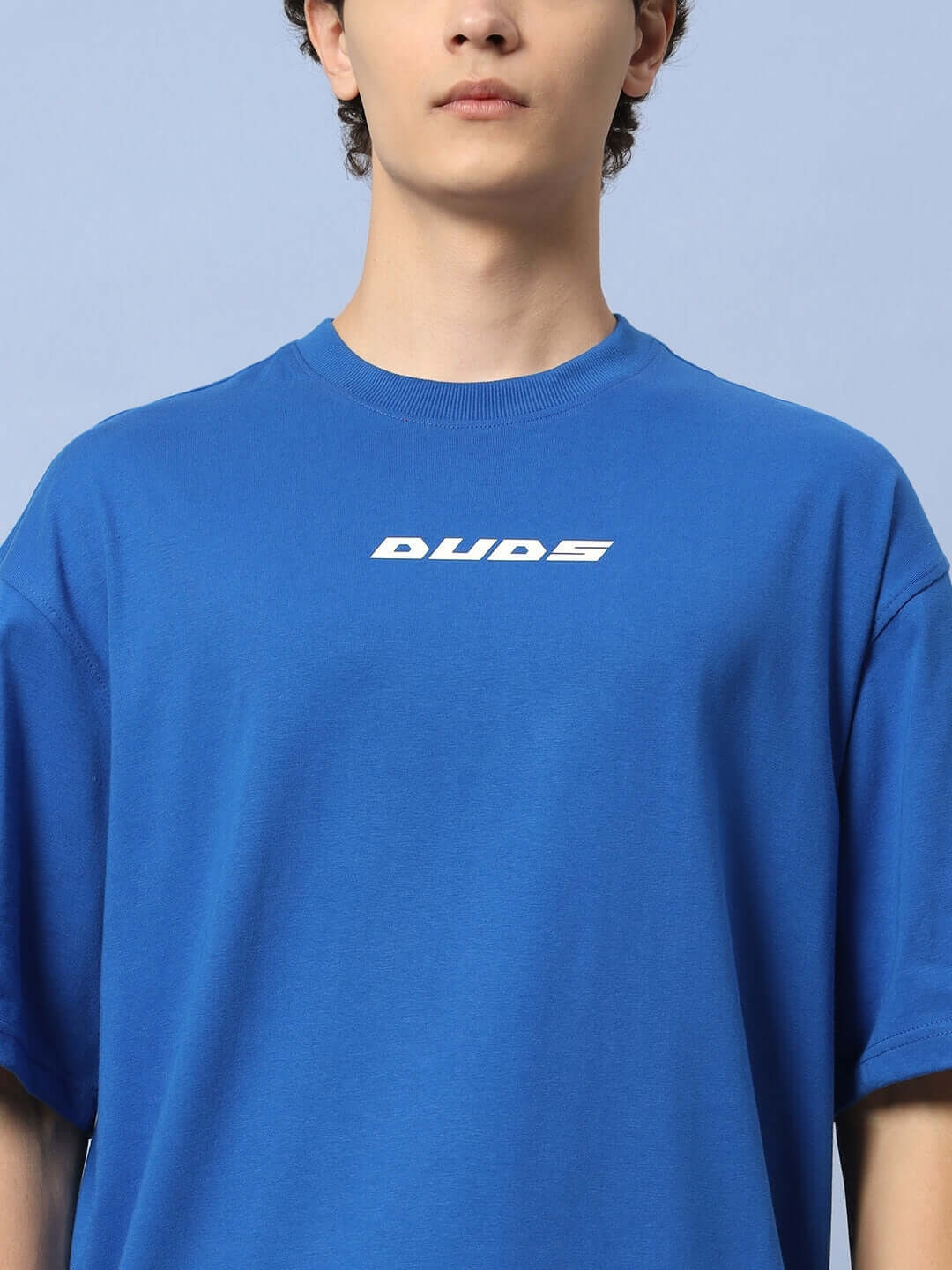 Person wearing LUNA OVER-SIZED T-SHIRT ROYAL BLUE with "Luna" graphic, showcasing streetwear style and relaxed fit.
