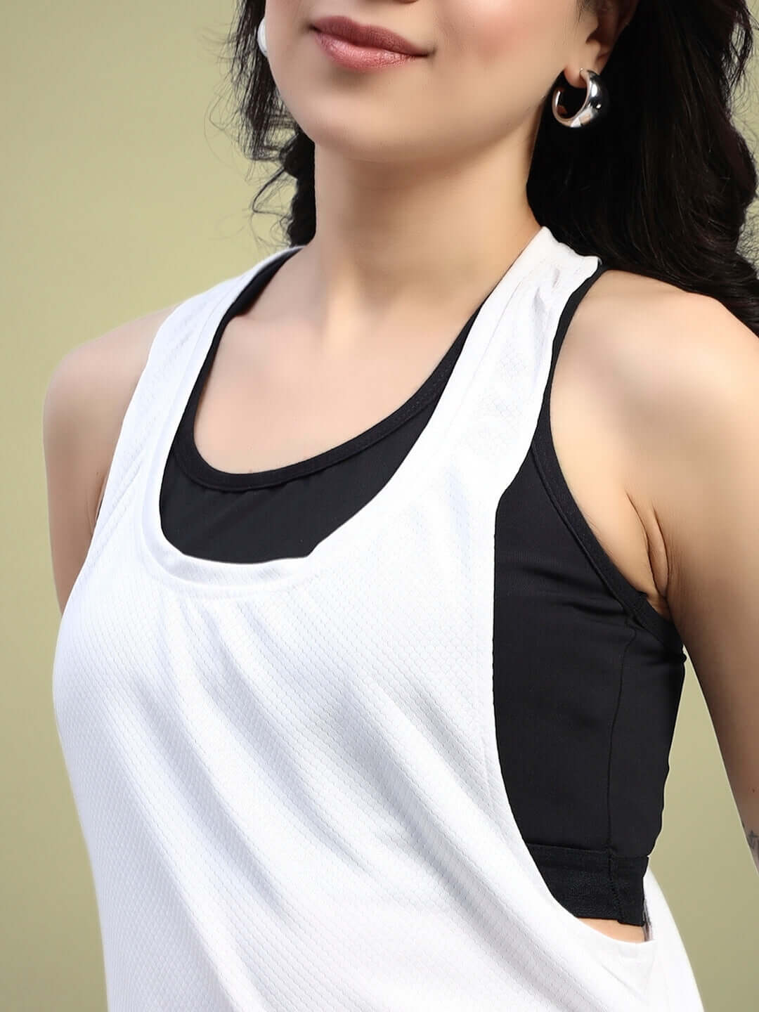 Woman wearing a white cubby co-ord set with black inner top, showcasing relaxed fit and sporty style.