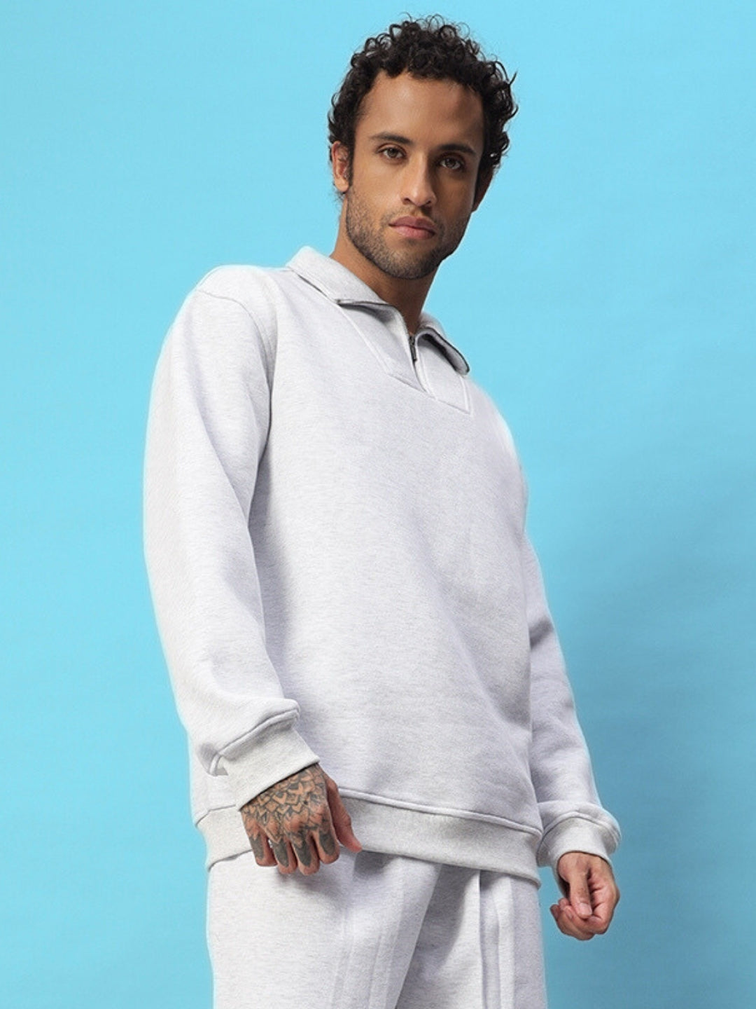 Model wearing BONA-FIDE fleece co-ord in melange grey against blue background.
