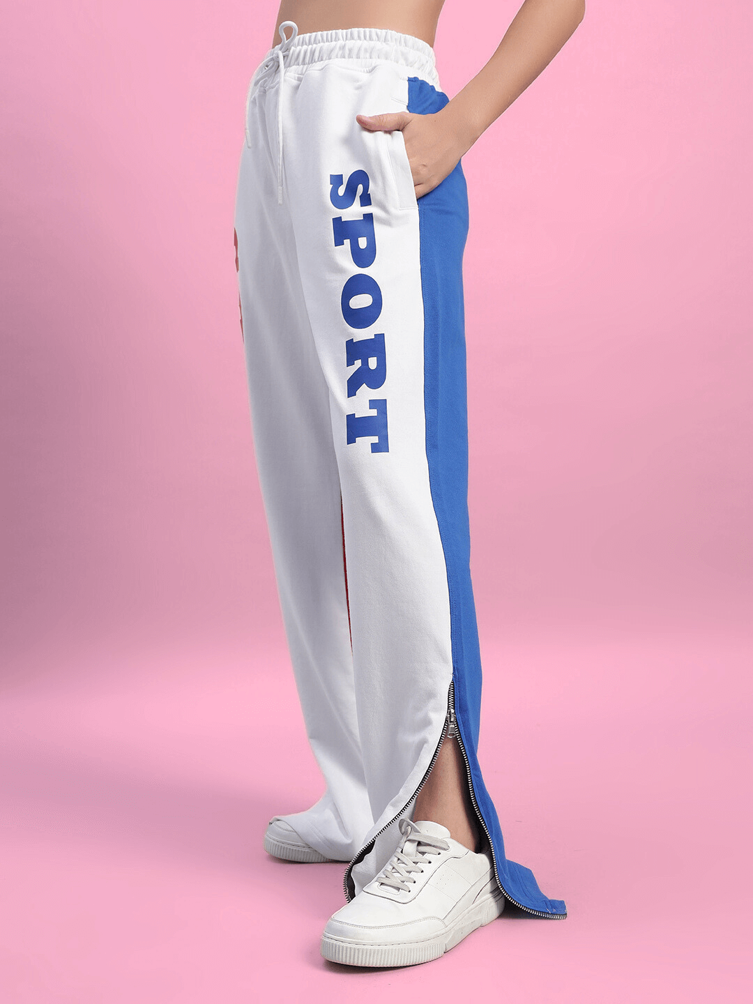 Women's urban drift relaxed fit joggers in multi-color with side pockets and 'SPORT' text on the leg, showcased on a pink background.