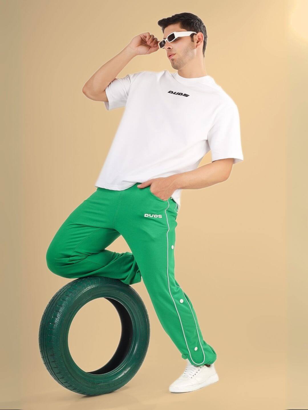 Model wearing DONT STOP OVER-SIZED T-SHIRT WHITE with green pants, striking a pose.