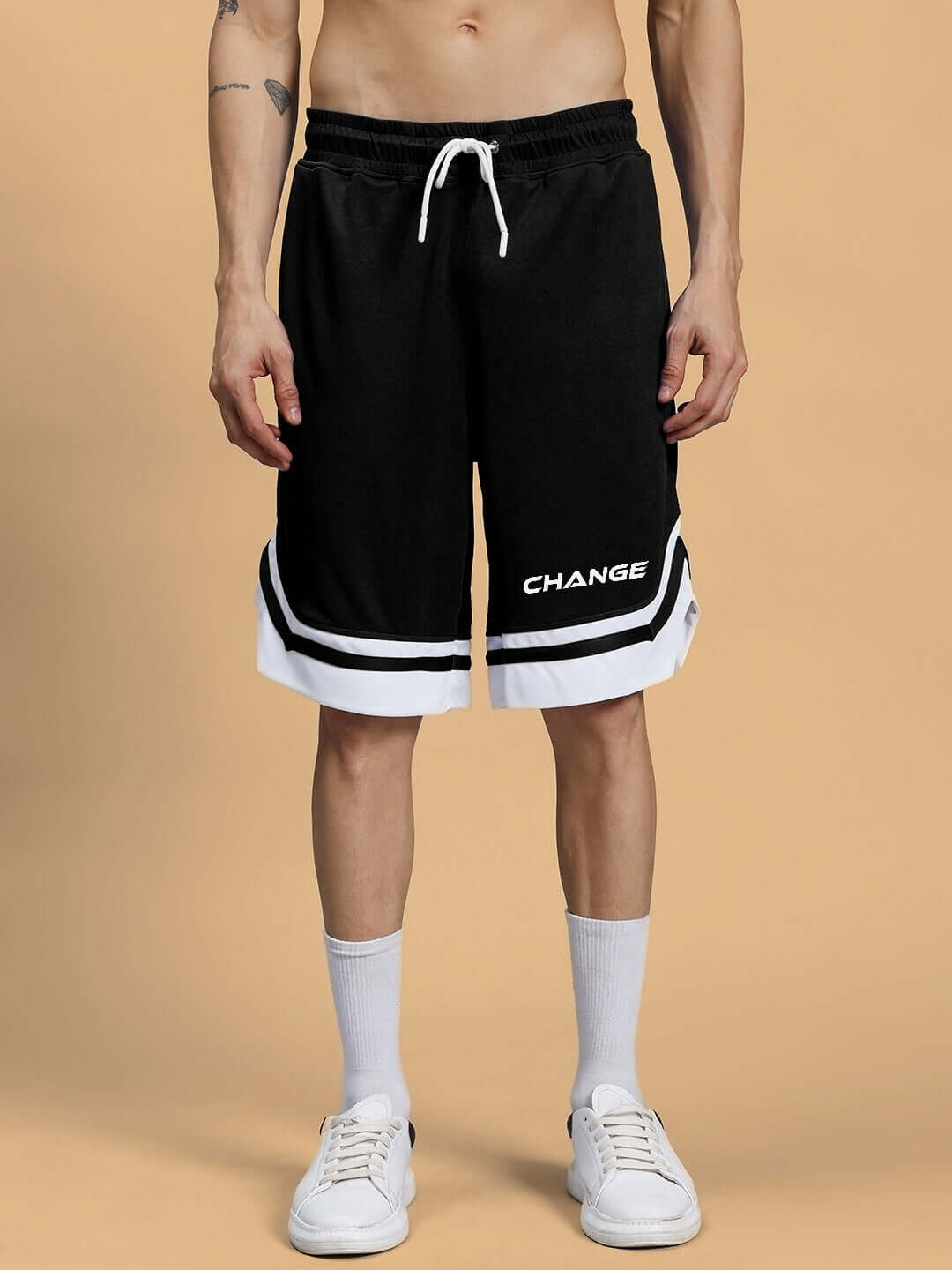 Person wearing black FLEX regular fit shorts with 'Change' text, featuring an adjustable waistband and white trim.