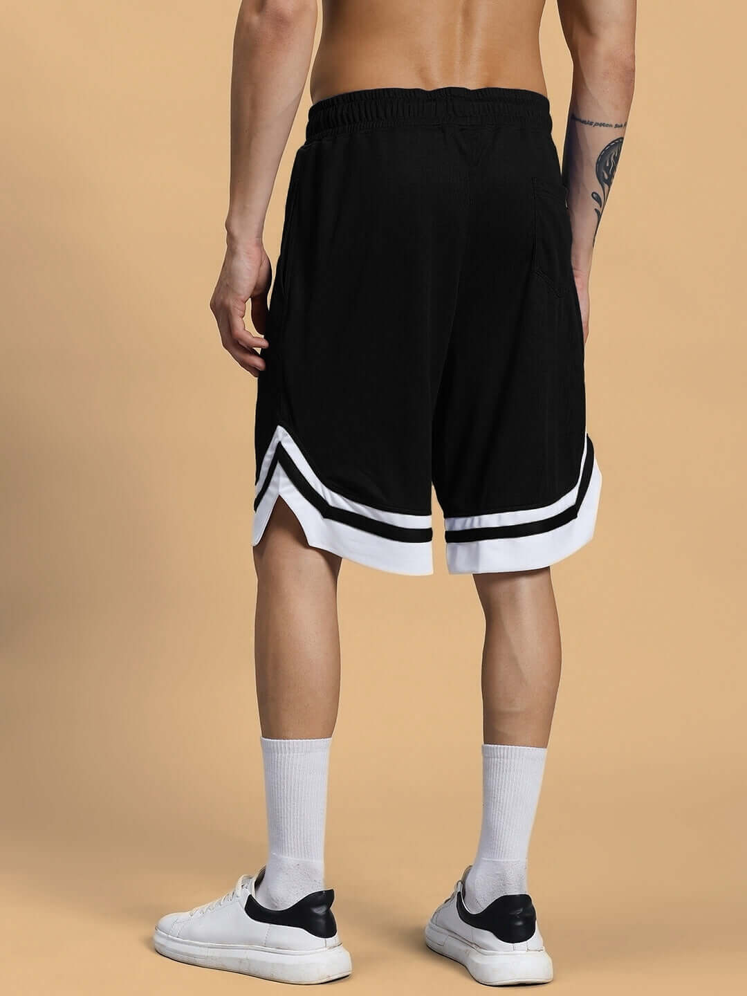 Man modeling black regular fit customizable shorts with white stripes, showcasing rear view for CHANGE YOUR LOOKS collection.