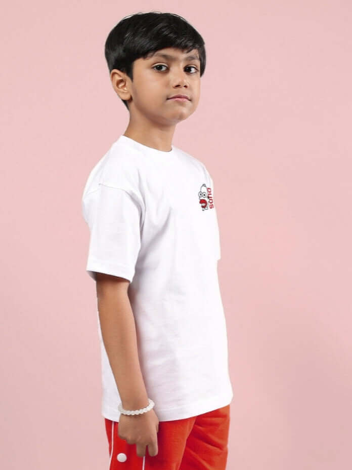 Boy wearing white Simpson-themed oversized T-shirt, side view, pink background.