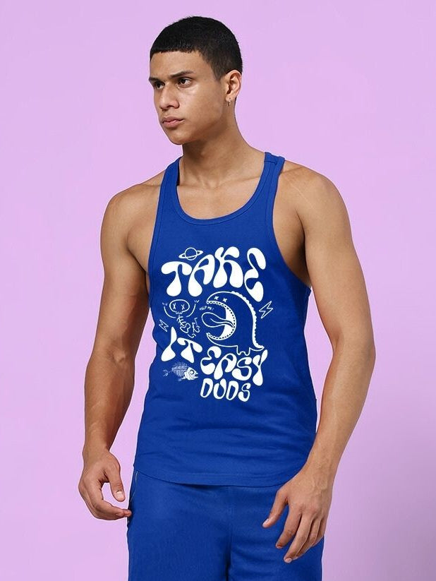 Man wearing TAKE IT EASY GYM VEST T-SHIRT BLUE with graphic design, showcasing casual athletic style.