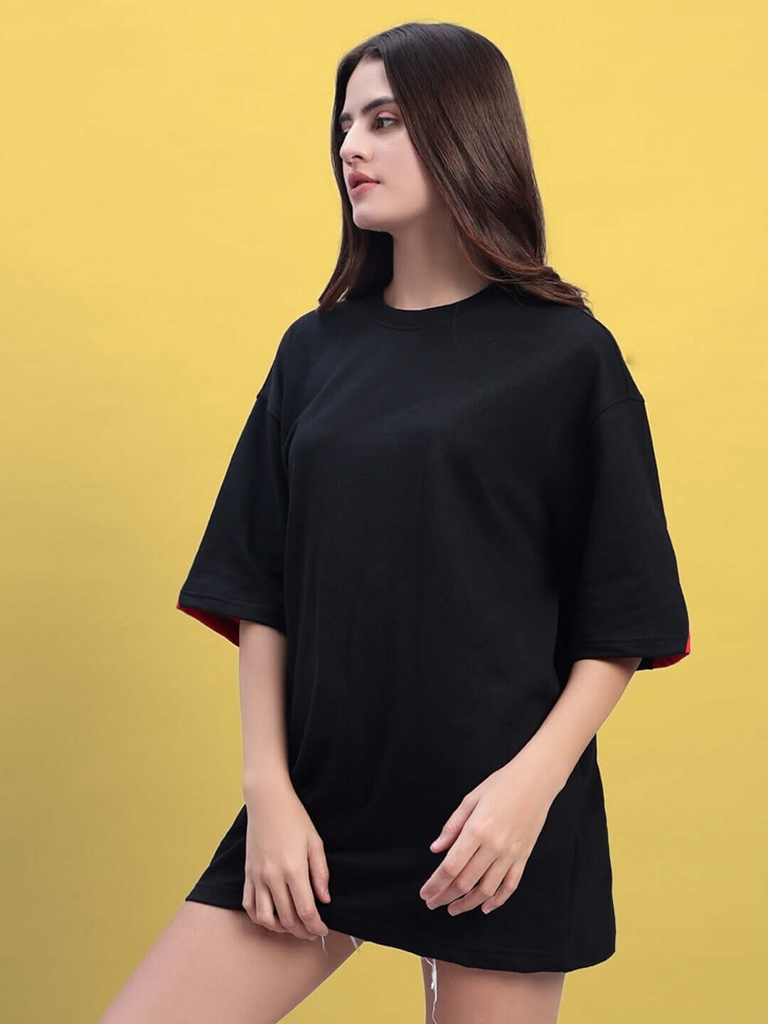 Woman wearing oversized black and red T-shirt made of premium cotton fabric.