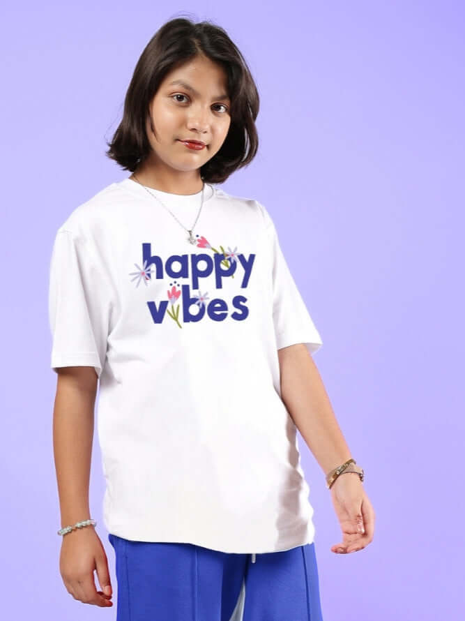 Child wearing a white Happy Vibes t-shirt, suitable for boys and girls, by DUDS.