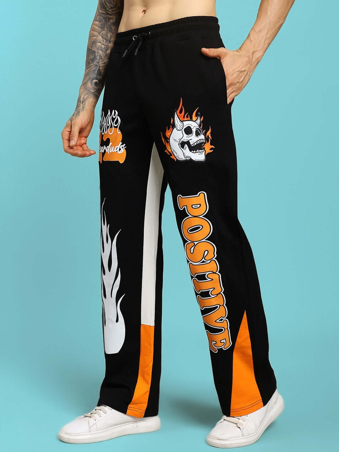 Black-orange relaxed fit joggers with skull and flame graphics, named Fearless Contrast Positive, tailored by DUDS.
