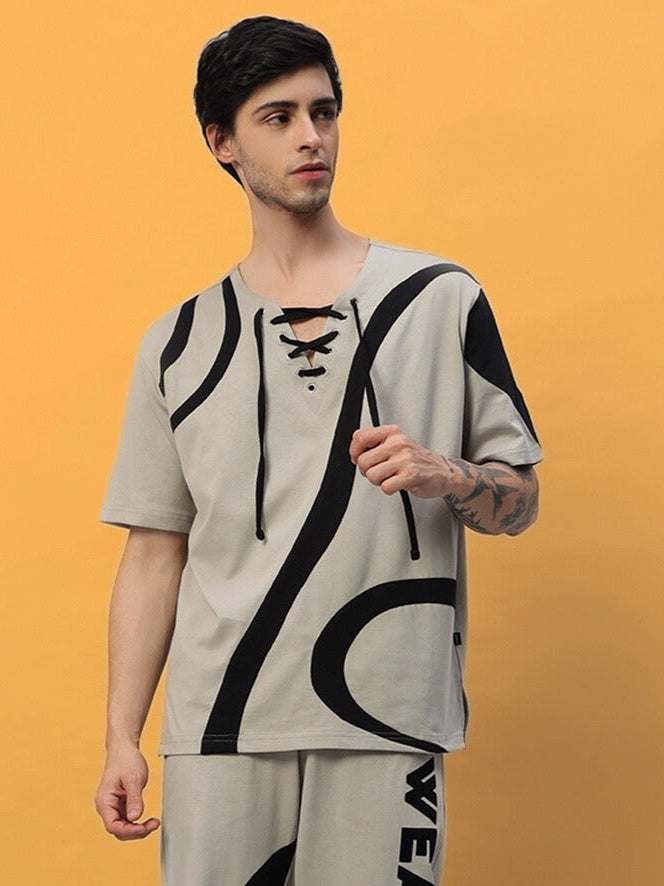 Model wearing grey surfing designer oversized T-shirt, featuring black abstract design. Made from premium cotton and elastane blend.