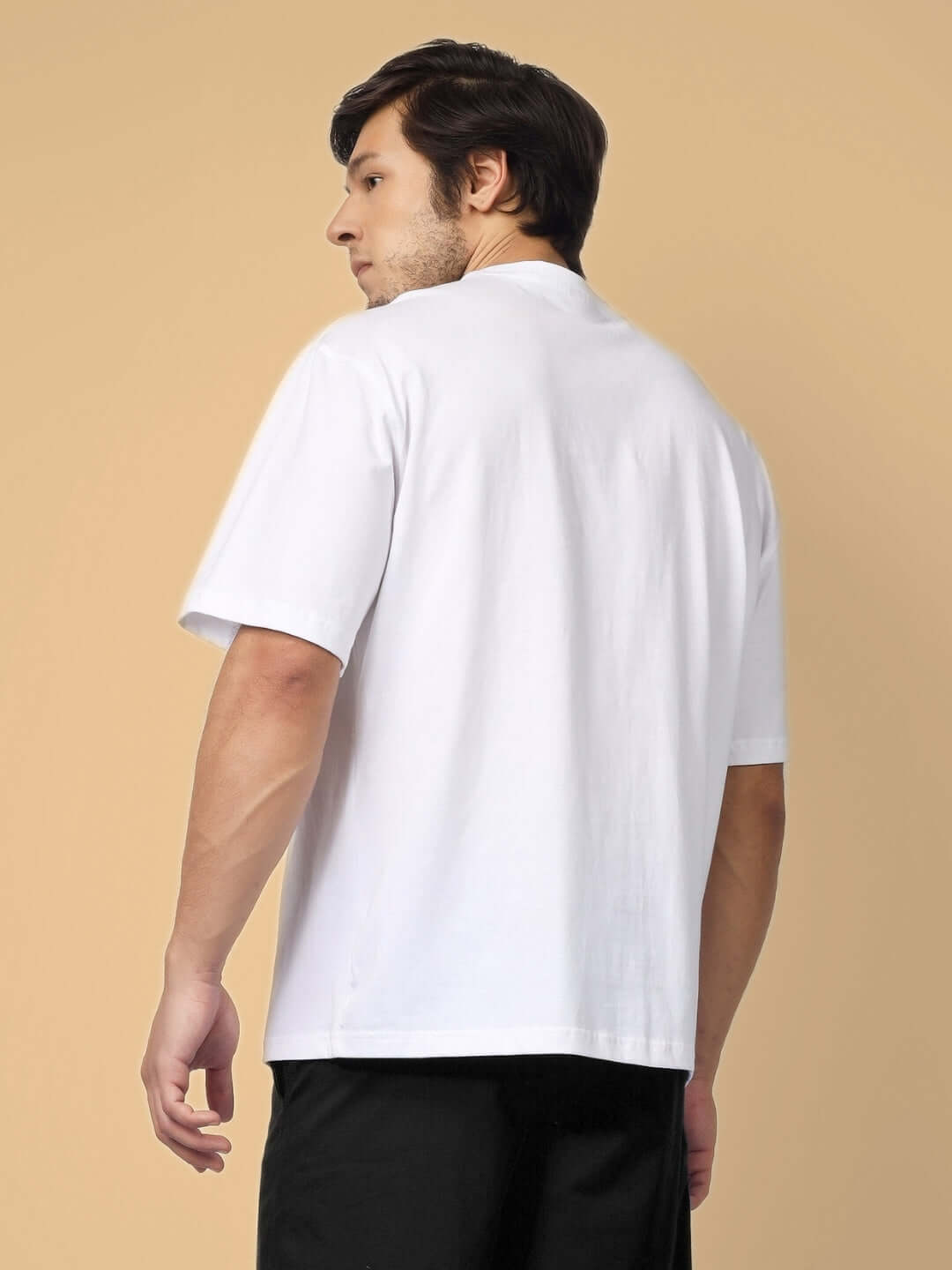 Man wearing white oversized cotton t-shirt, side view, showcasing casual fit and summer style, perfect for pairing with various outfits.