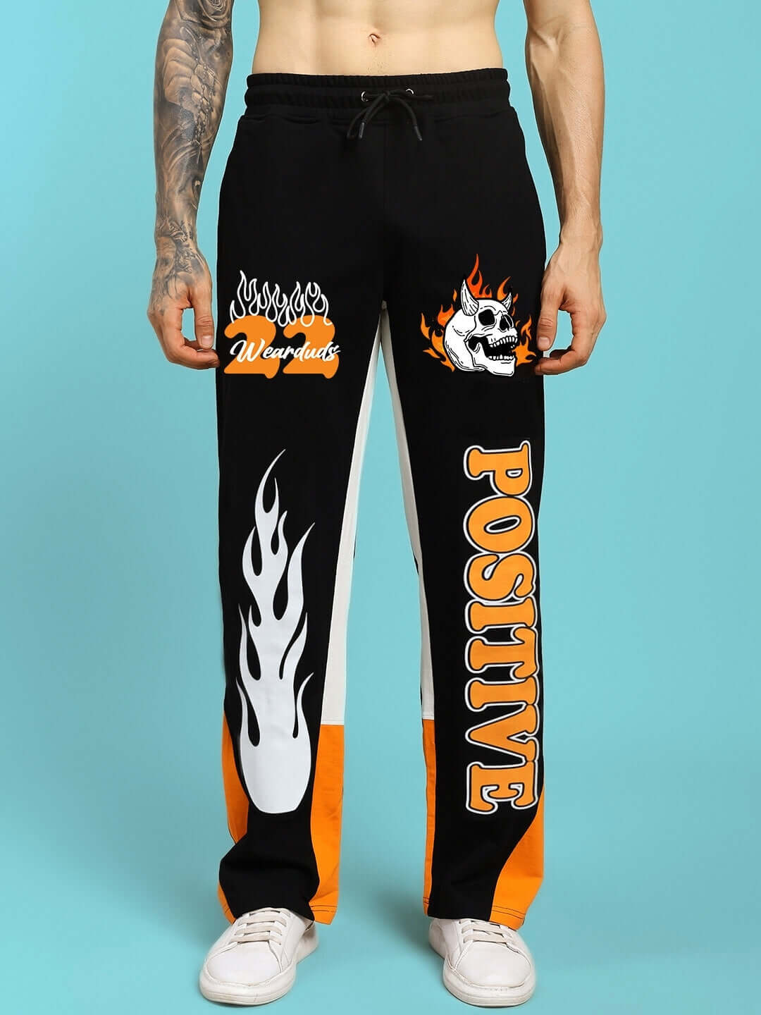 Black-orange relaxed fit joggers with flame and skull design, featuring 'Positive' text. Tailored by DUDS, customizable for prepaid orders.