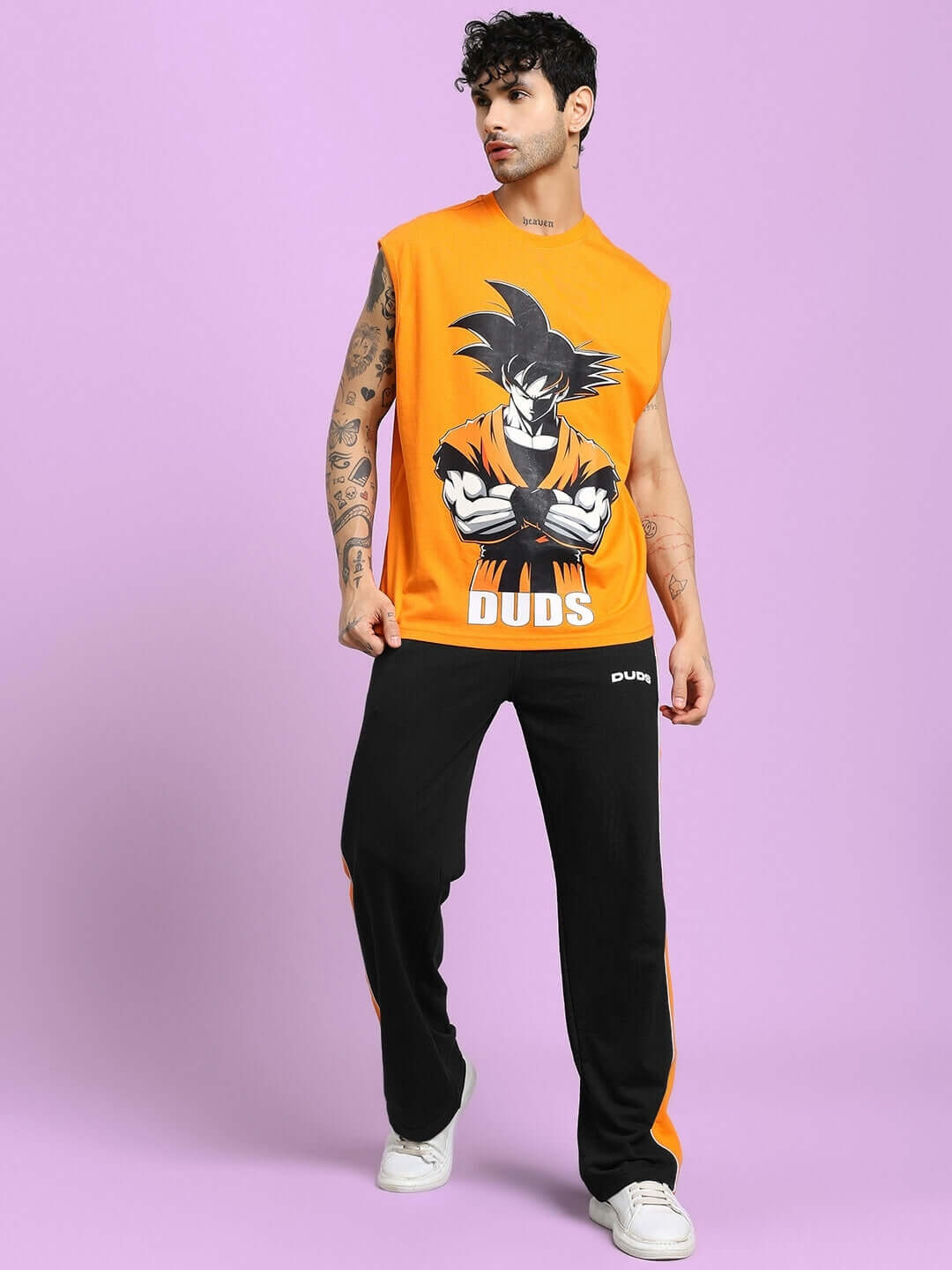 Man wearing Sanford Stripe Joggers in black with orange detailing on a purple background.
