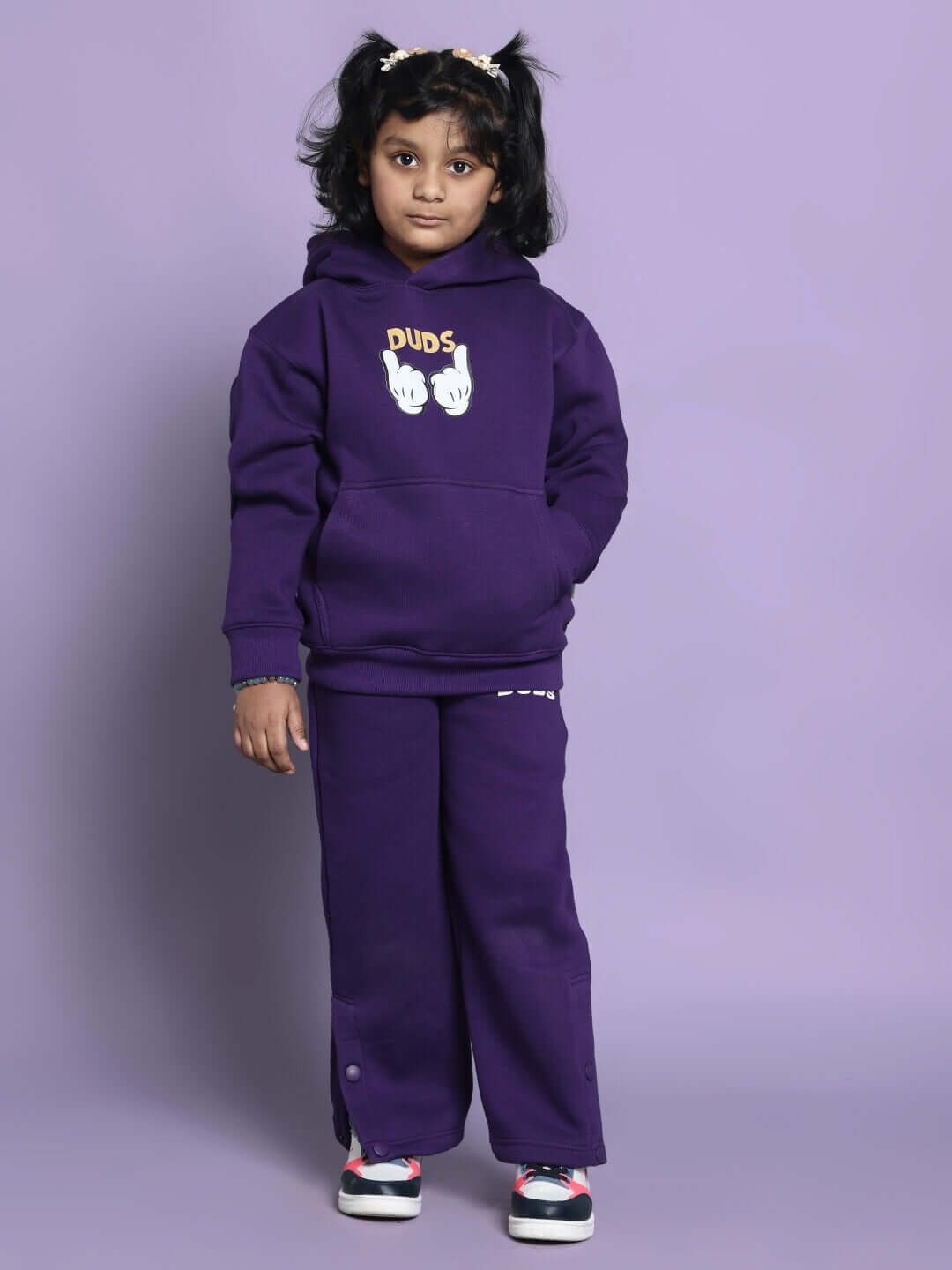 Child wearing Miller purple co-ord set for boys and girls with hoodie and pants, featuring a playful design on the front.