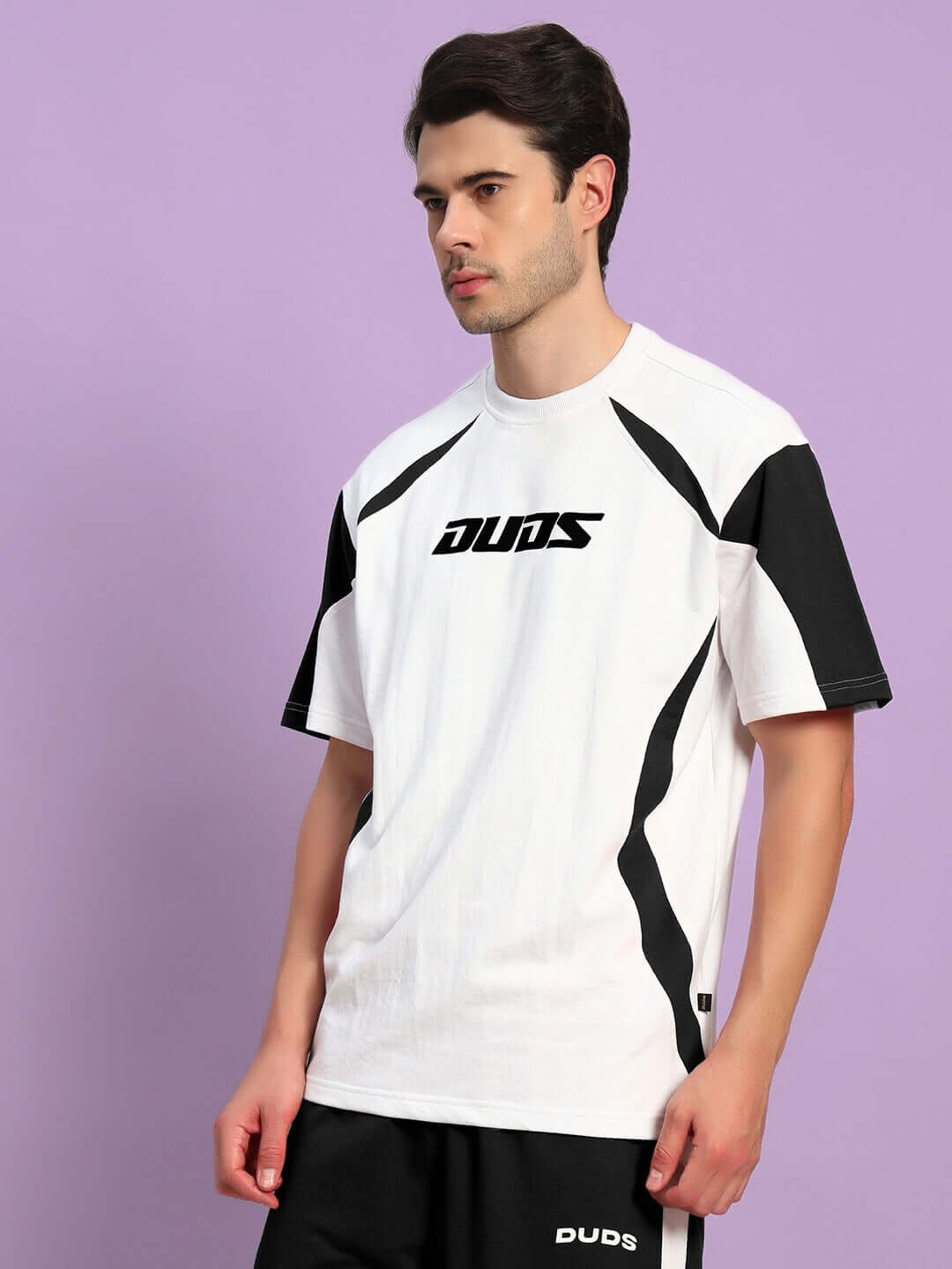 Model wearing Candor oversized white and black t-shirt made of premium cotton French terry and elastane, perfect for casual style.